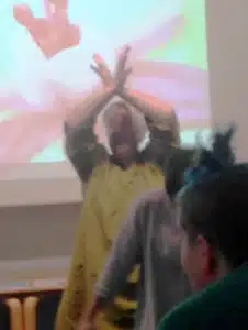 person during workshop with their arms above their head