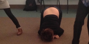 person during a workshop curled up into a ball on the floor