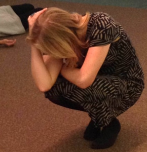 person during a workshop curled up into a ball on the floor