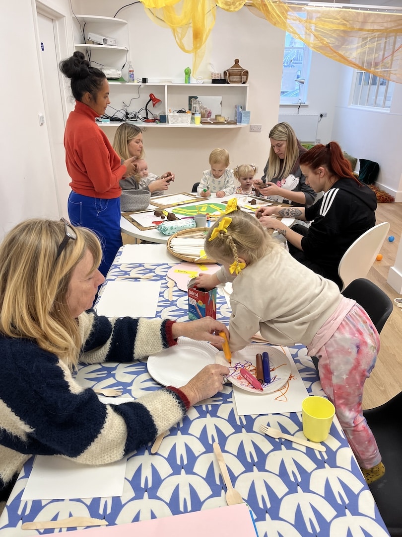 Adults and children at table doing crafts