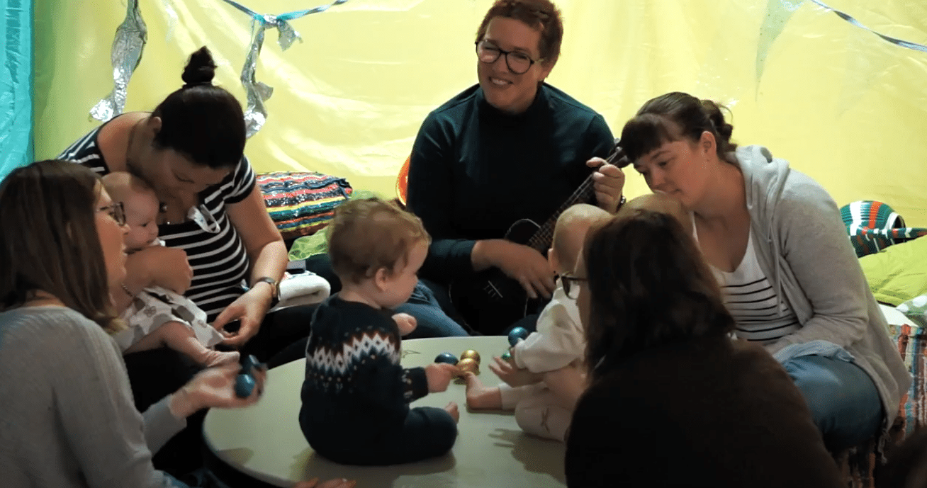 Babies and adults playing on floor