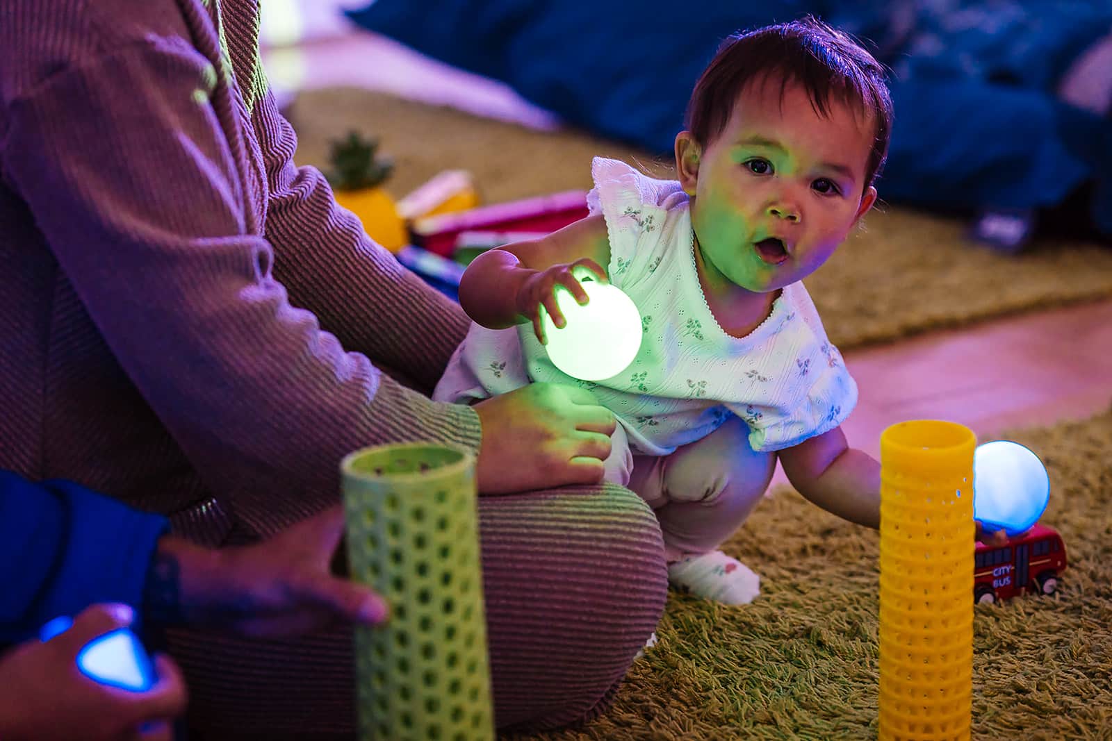 Toddler holding glowing ball and playing
